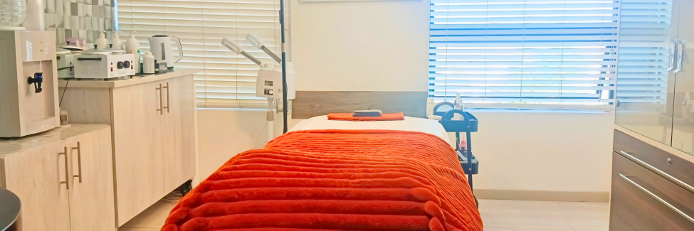 Waxbae treatment room with a prepared treatment bed and warm spa setting