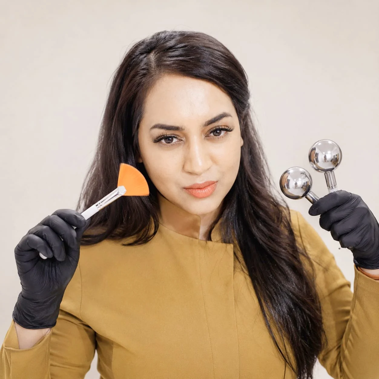 Vee, founder and therapist at Waxbae, holding facial treatment tools